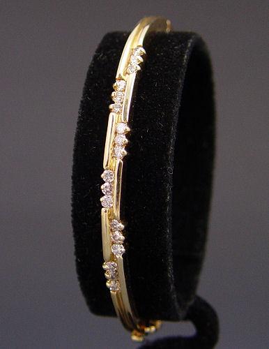 Appraisal: K DIAMOND BANGLE BRACELET K yellow gold bangle bracelet contains