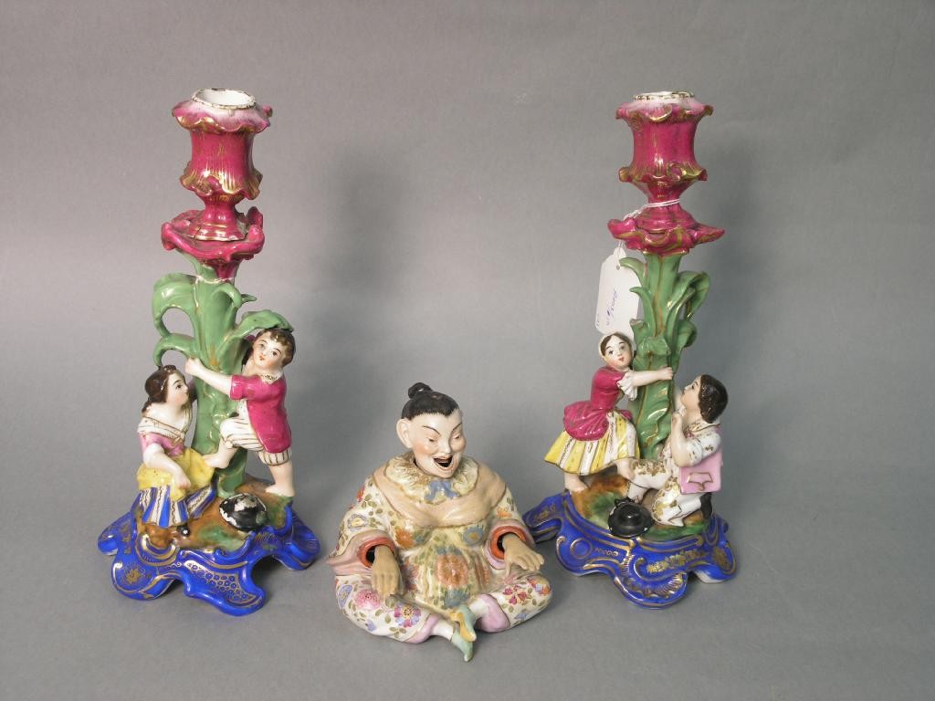 Appraisal: A pair of th Century Continental porcelain candlesticks figural stems