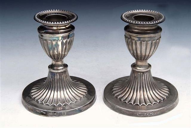 Appraisal: A PAIR OF LATE VICTORIAN SILVER DWARF CANDLESTICKS with reeded