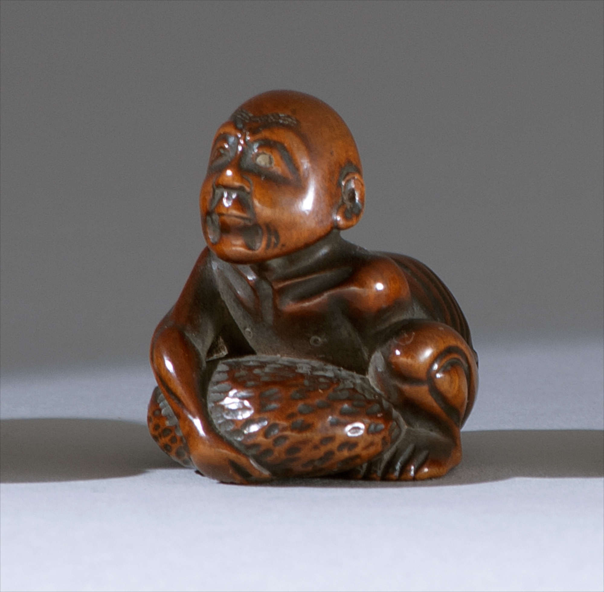 Appraisal: WOOD NETSUKE Early th CenturyDepicting a blind stone lifter Height