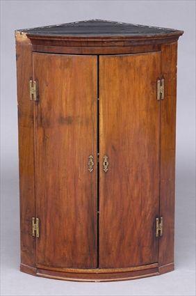 Appraisal: GEORGE III GILT-METAL-MOUNTED MAHOGANY HANGING CORNER CUPBOARD The bow-fronted molded