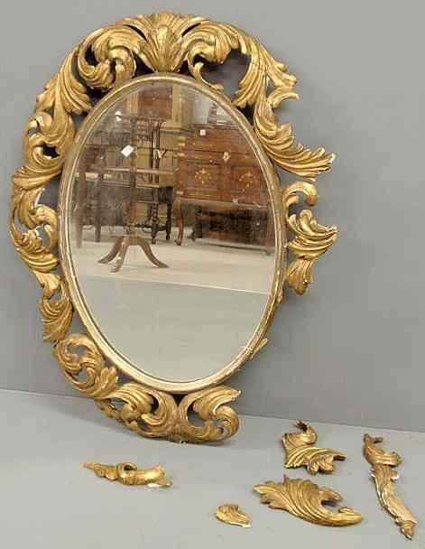 Appraisal: Italian ornately carved gilt oval mirror mid th c As