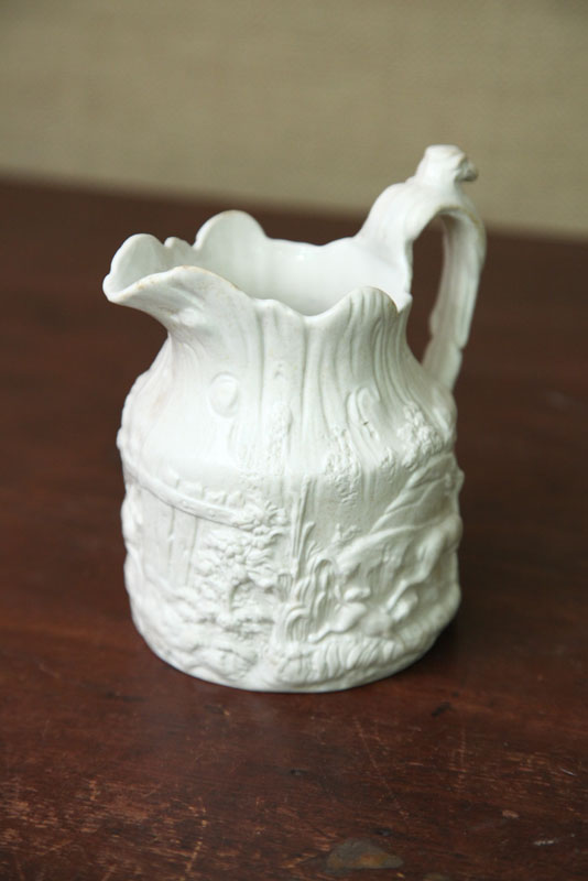 Appraisal: BENNINGTON PITCHER Parian type pitcher with embossed forest scene and