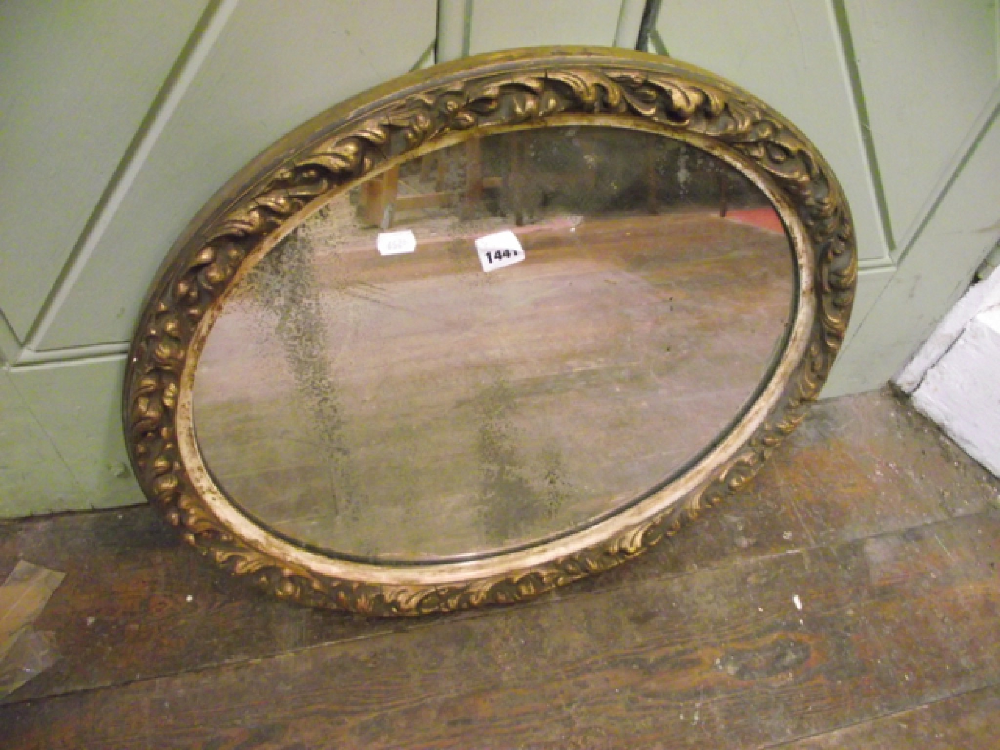 Appraisal: An oval gilded wall mirror with acanthus and other detail