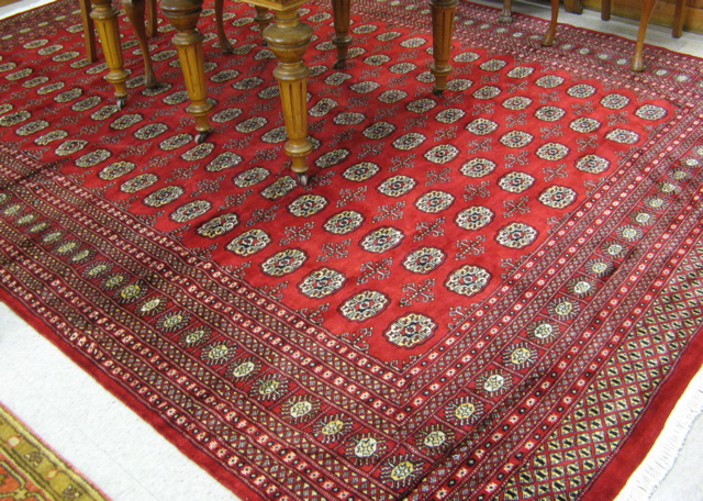 Appraisal: PAKISTANI BOKHARA CARPET overall Turkoman gol design on bright red