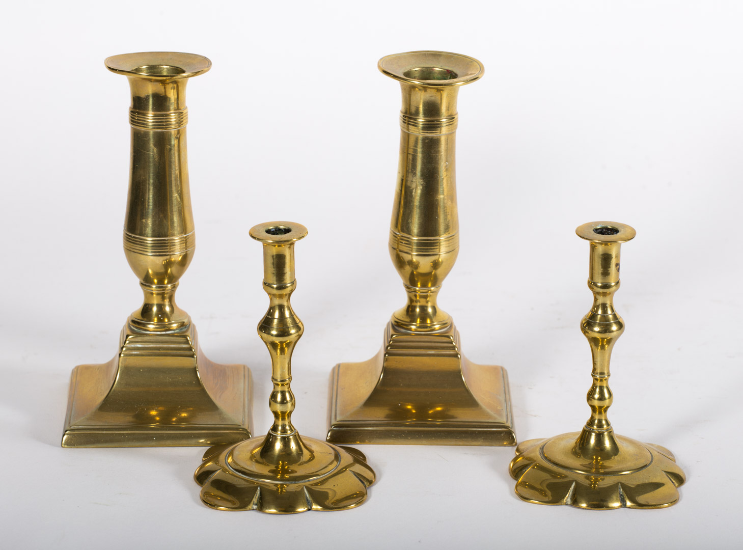 Appraisal: Two pairs of brass candlesticks pair Queen Anne petal base