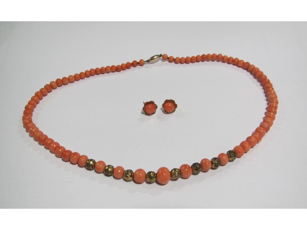 Appraisal: String of coral beads with gilt metal rose decorated ball