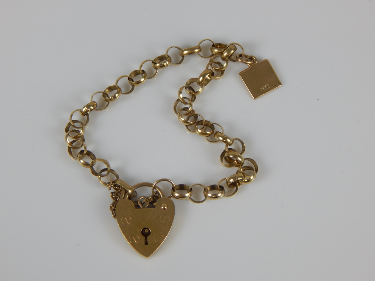 Appraisal: A ct gold charm bracelet with padlock and single charm