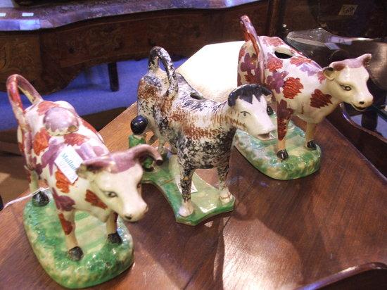 Appraisal: A PAIR OF STAFFORDSHIRE POTTERY COW CREAMERS on naturalistic bases