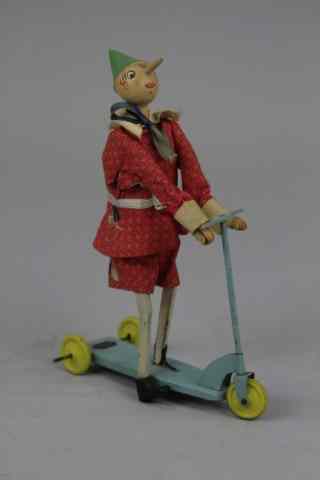 Appraisal: BREVETTATO PINOCCHIO ON SCOOTER Italy cloth suited figure wooden head