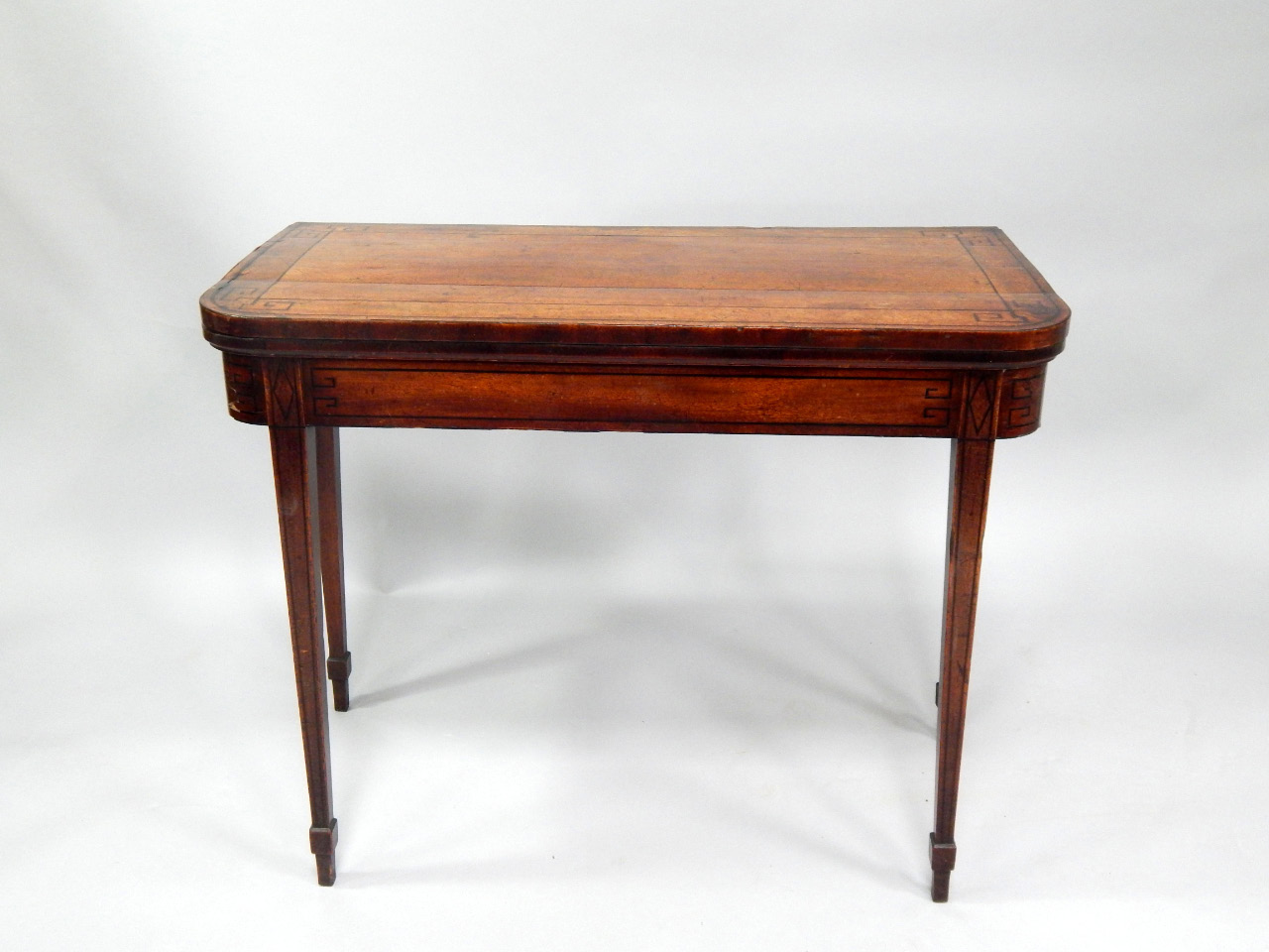 Appraisal: A George III mahogany card table with ebony strung folding