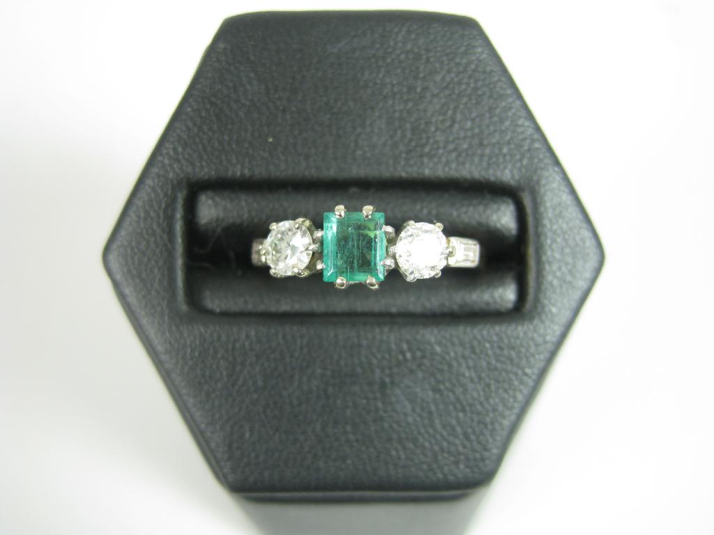 Appraisal: A three stone Emerald and Diamond Ring claw-set central step-cut