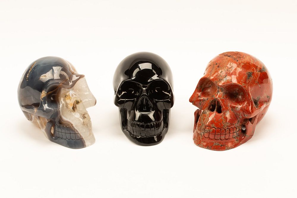 Appraisal: A Set of Three Obsidian Agate and Red Jasper Skulls