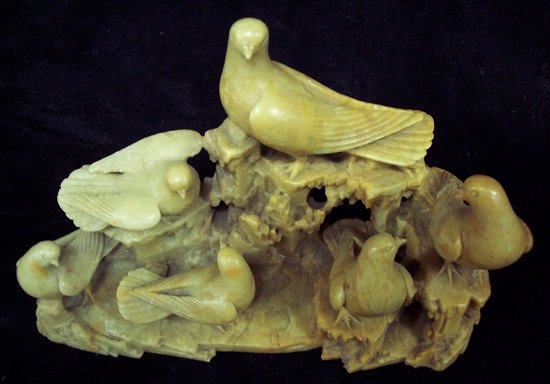 Appraisal: A carved soapstone group depicting doves on a naturalistic rocky