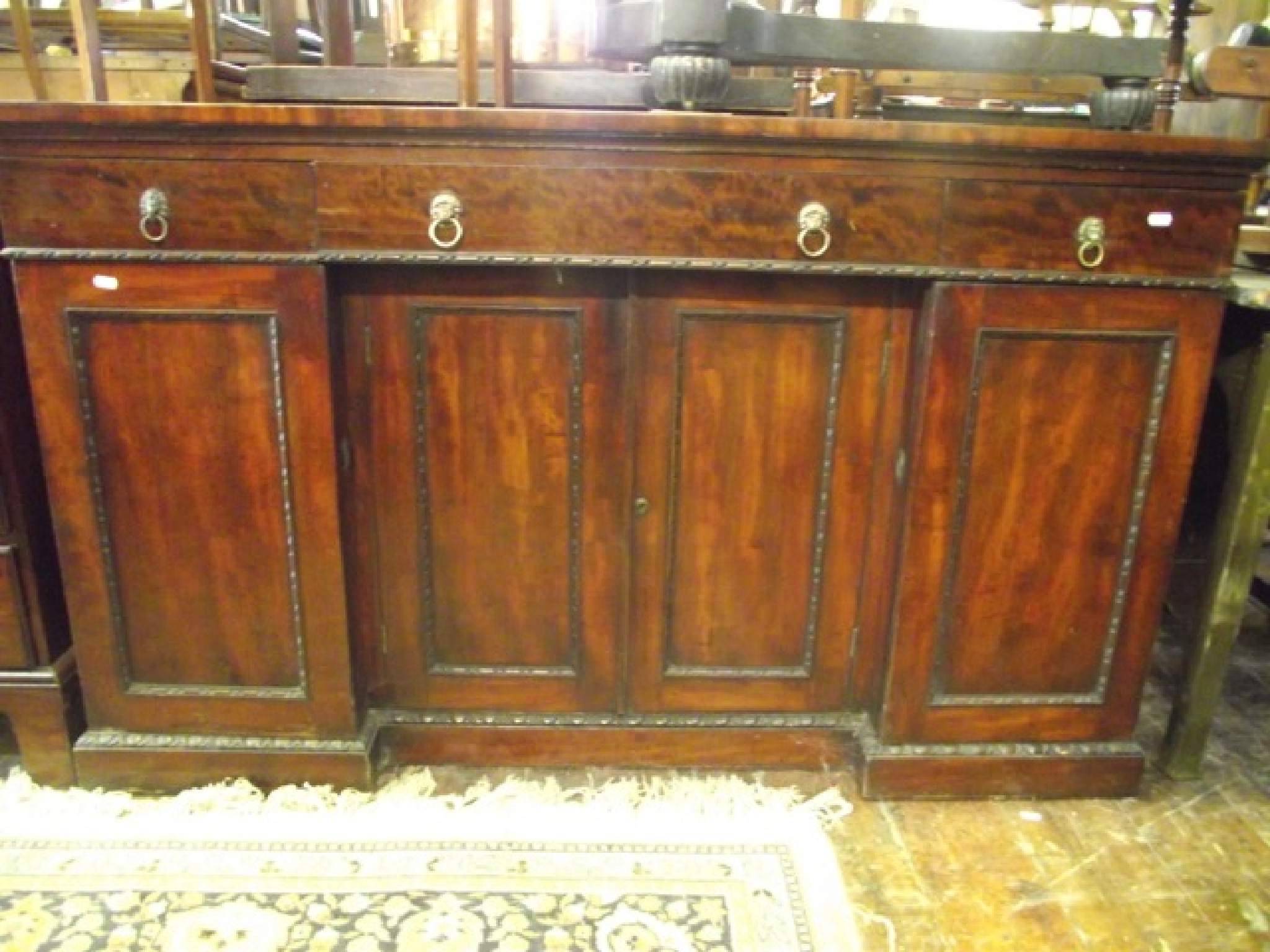 Appraisal: A Regency mahogany inverted break front side cupboard enclosed by