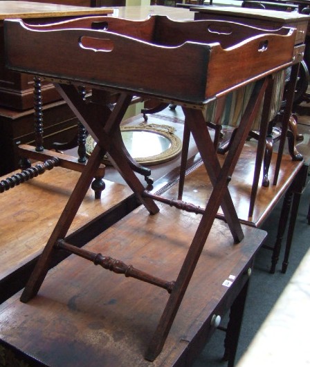 Appraisal: A th century mahogany butlers tray on stand with pierced