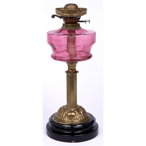 Appraisal: An Edwardian brass oil lamp with cranberry glass fount and