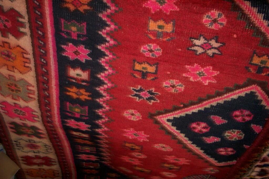 Appraisal: A red ground Eastern wool rug with geometric decoration in