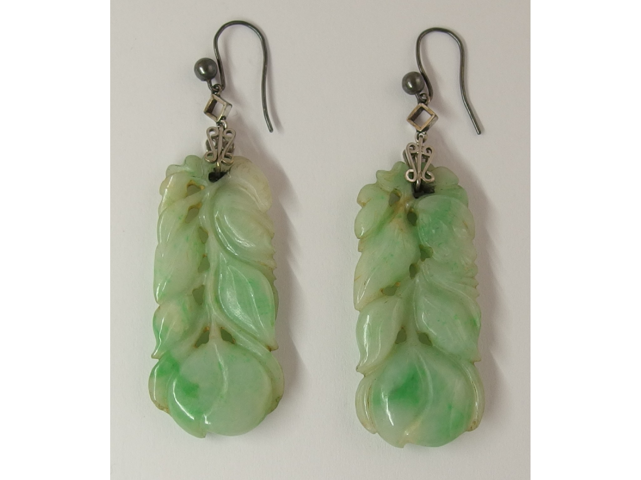 Appraisal: A pair of Chinese green hardstone earringscarved with peaches foliage