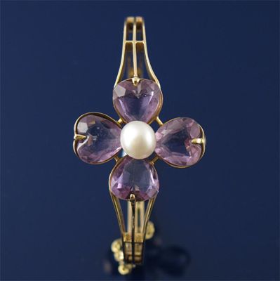 Appraisal: A gold hinged bangle with an amethyst and bouton pearl