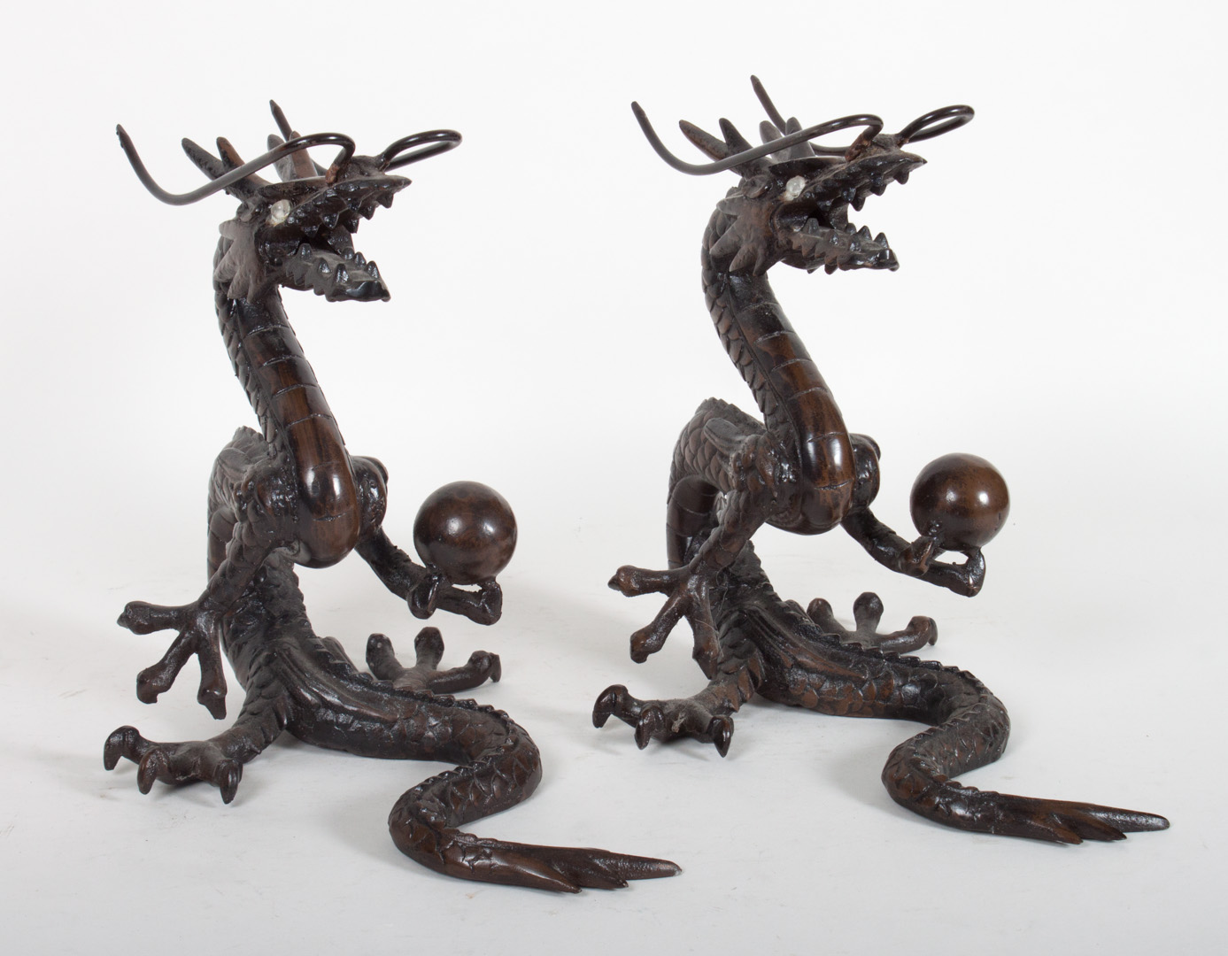 Appraisal: Pair of Chinese cast bronze dragons each seated holding pearl