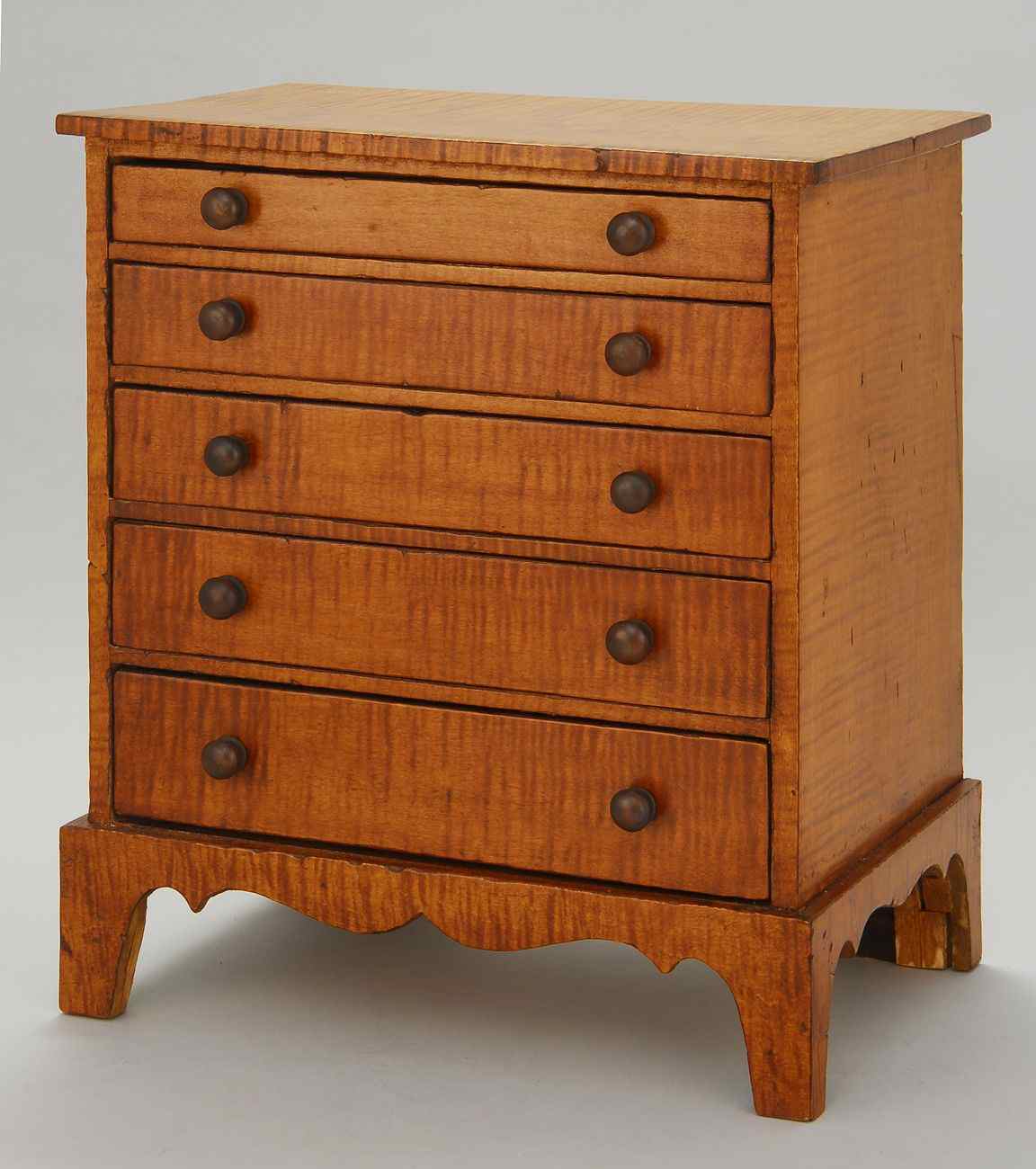 Appraisal: MINIATURE CHIPPENDALE-STYLE FIVE-DRAWER CHESTLate th Century Early th CenturyIn tiger