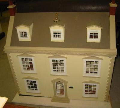 Appraisal: A Georgian style painted wood dolls house with pedimented windows