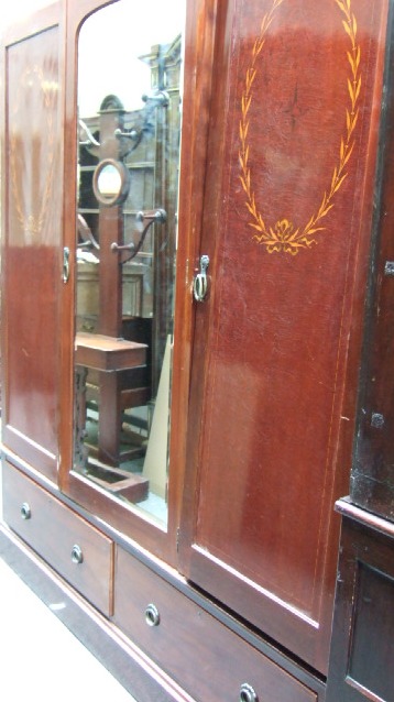 Appraisal: An Edwardian inlaid mahogany triple wardrobe the plain stepped cornice