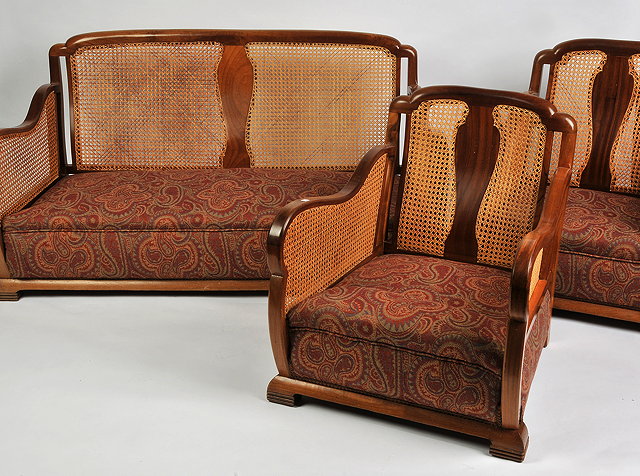 Appraisal: A WALNUT FRAMED BERGERE SUITE comprising a two seater sofa