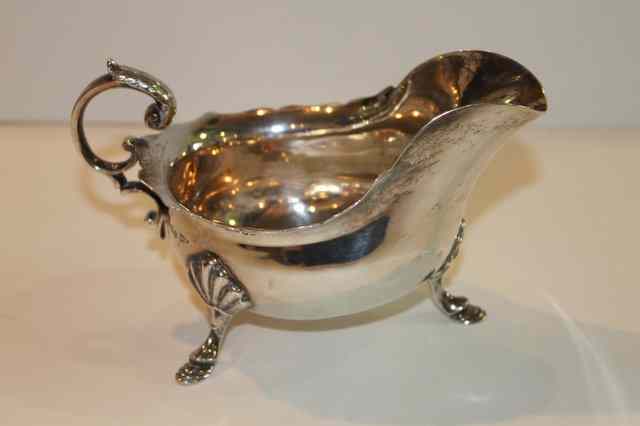 Appraisal: A GEORGIAN STYLE SILVER SAUCE BOAT with shaped border cabriole