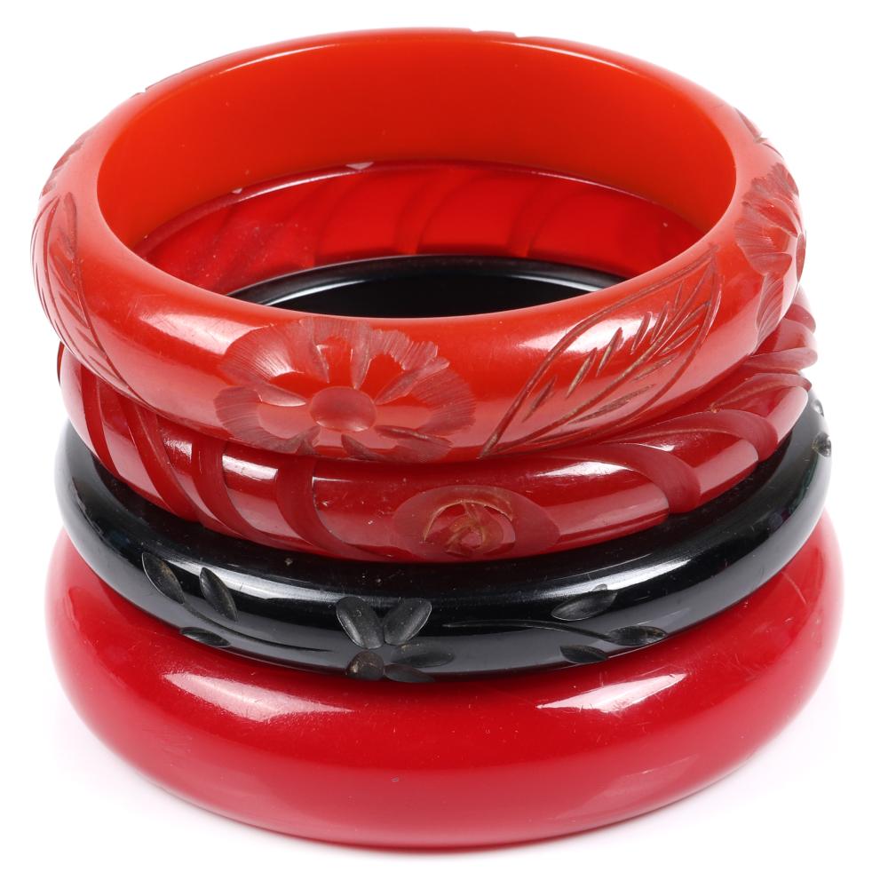 Appraisal: FOUR BAKELITE TOMATO RED AND BLACK CARVED BANGLE BRACELETS THREE