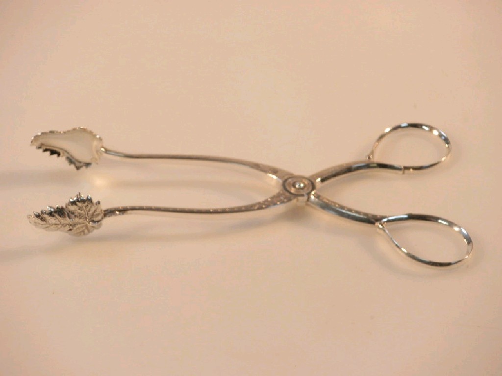 Appraisal: A pair of white metal sugar nips with leaf bowls