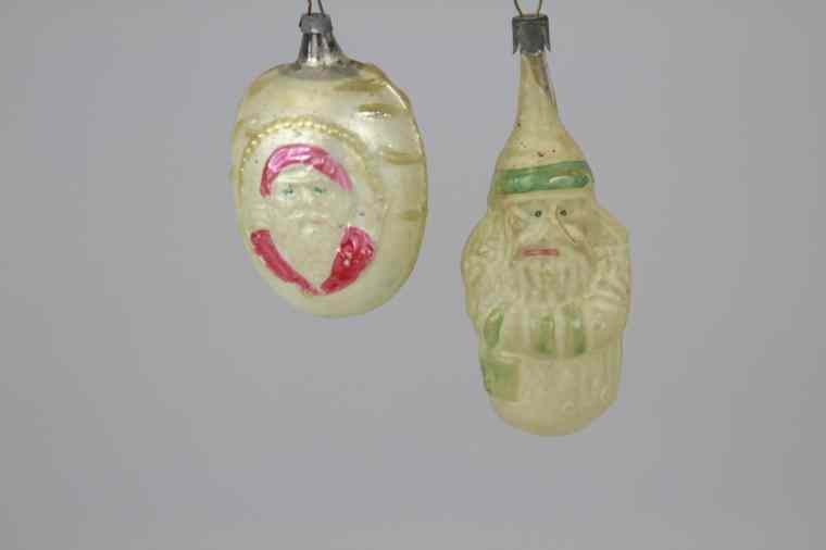 Appraisal: SANTA ON OVAL SANTA WITH BASKET ORNAMENTS Germany blown glass