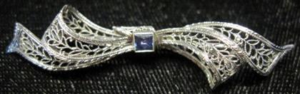 Appraisal: karat white gold sapphire 'bow' pinFiligree accented by one Square