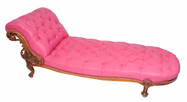 Appraisal: A WALNUT FRAMED PINK BUTTON UPHOLSTERED CHAISE LONGUE with carved