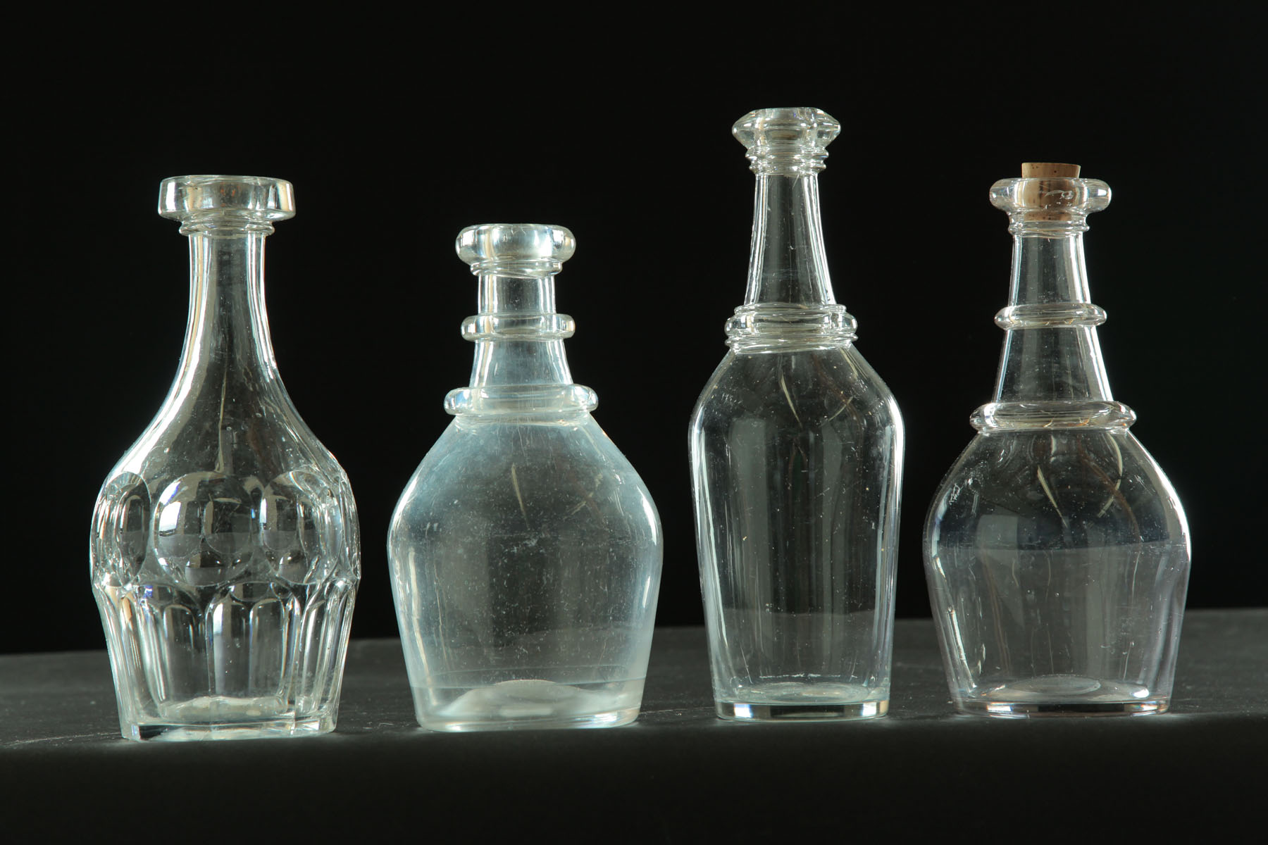 Appraisal: FOUR BAR BOTTLES American mid th century Clear blown glass