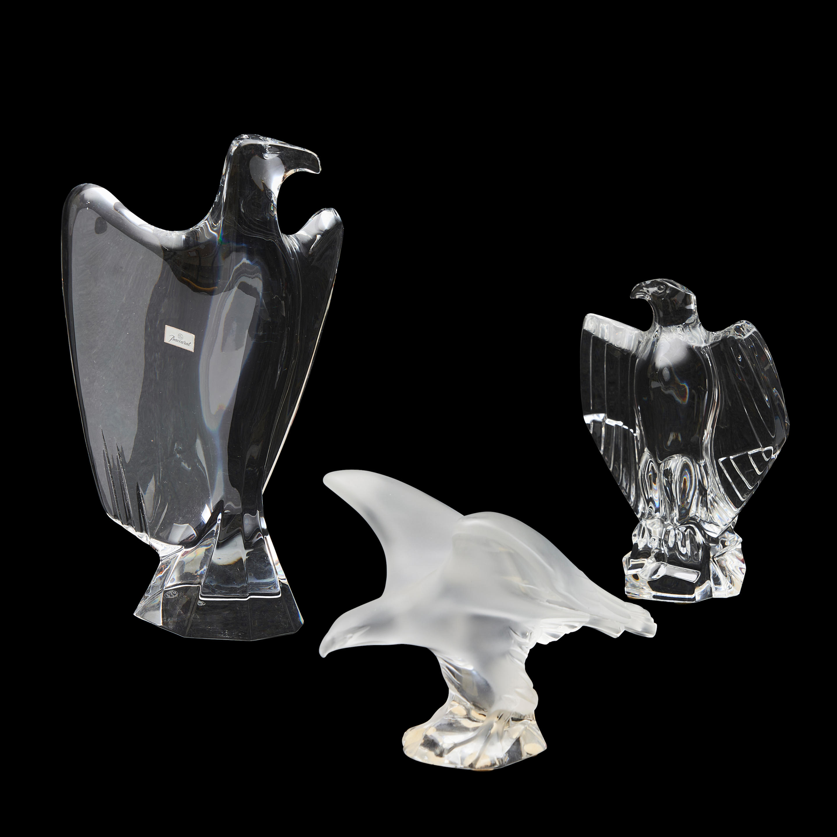 Appraisal: THREE MODERN COLORLESS GLASS EAGLES two Baccarat eagles and a