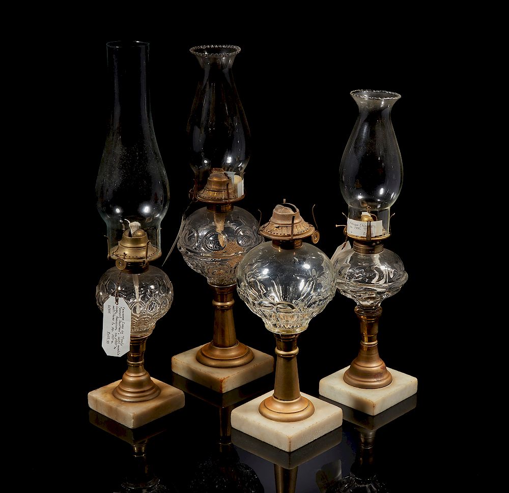 Appraisal: Four Kerosene Lamps Four assorted glass kerosene lamps on marble