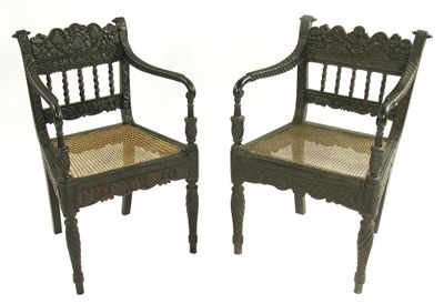 Appraisal: Two mid th century Anglo-Indian ebony open armchairs each with