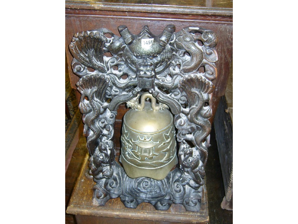 Appraisal: A Chinese bell with relief decoration on a carved hardwood