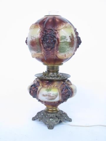 Appraisal: An antique hurricane lamp with lion shade and scenic landscape