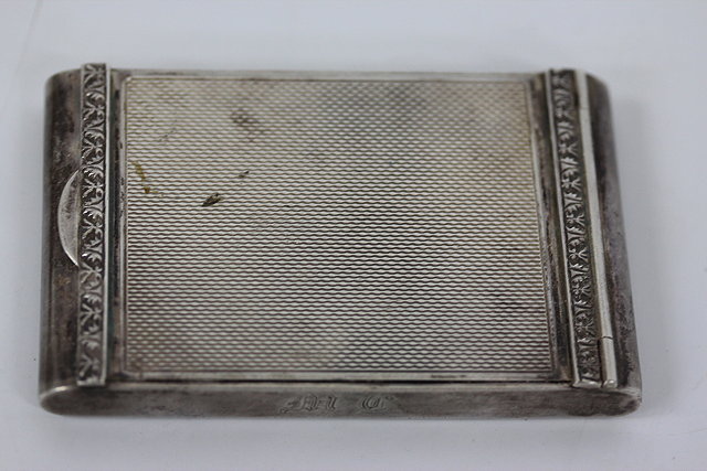 Appraisal: A RECTANGULAR SILVERED COMPACT with engine turned decoration to the