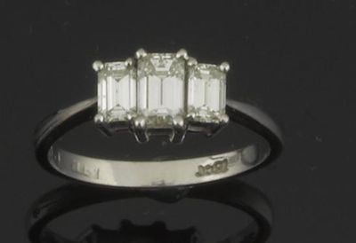 Appraisal: A diamond three stone ring The emerald cut diamonds weigh