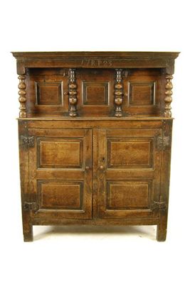 Appraisal: A George I oak press cupboard the plain frieze inscribed