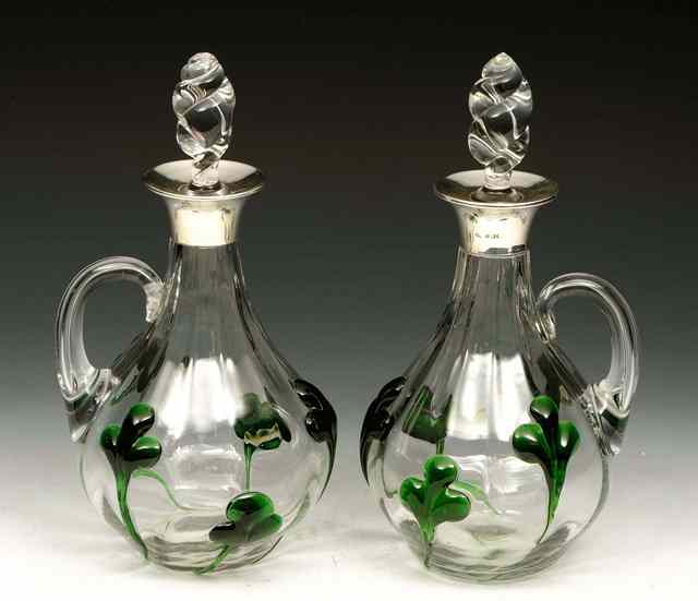 Appraisal: A PAIR OF SILVER MOUNTED GLASS DECANTERS with green glass