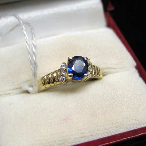 Appraisal: SAPPHIRE DIAMOND AND FOURTEEN KARAT GOLD RING centering an oval-cut