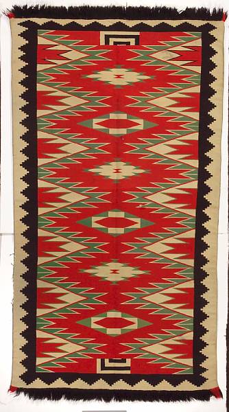 Appraisal: A Navajo Germantown rug Aligning a central row of diamond