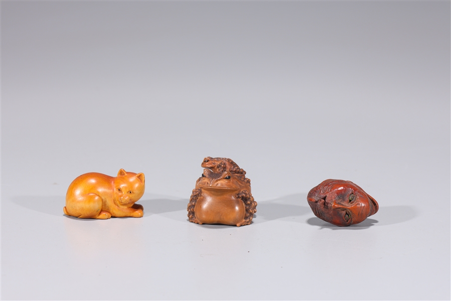 Appraisal: Three Japanese various carved wood netsuke double mask and frog