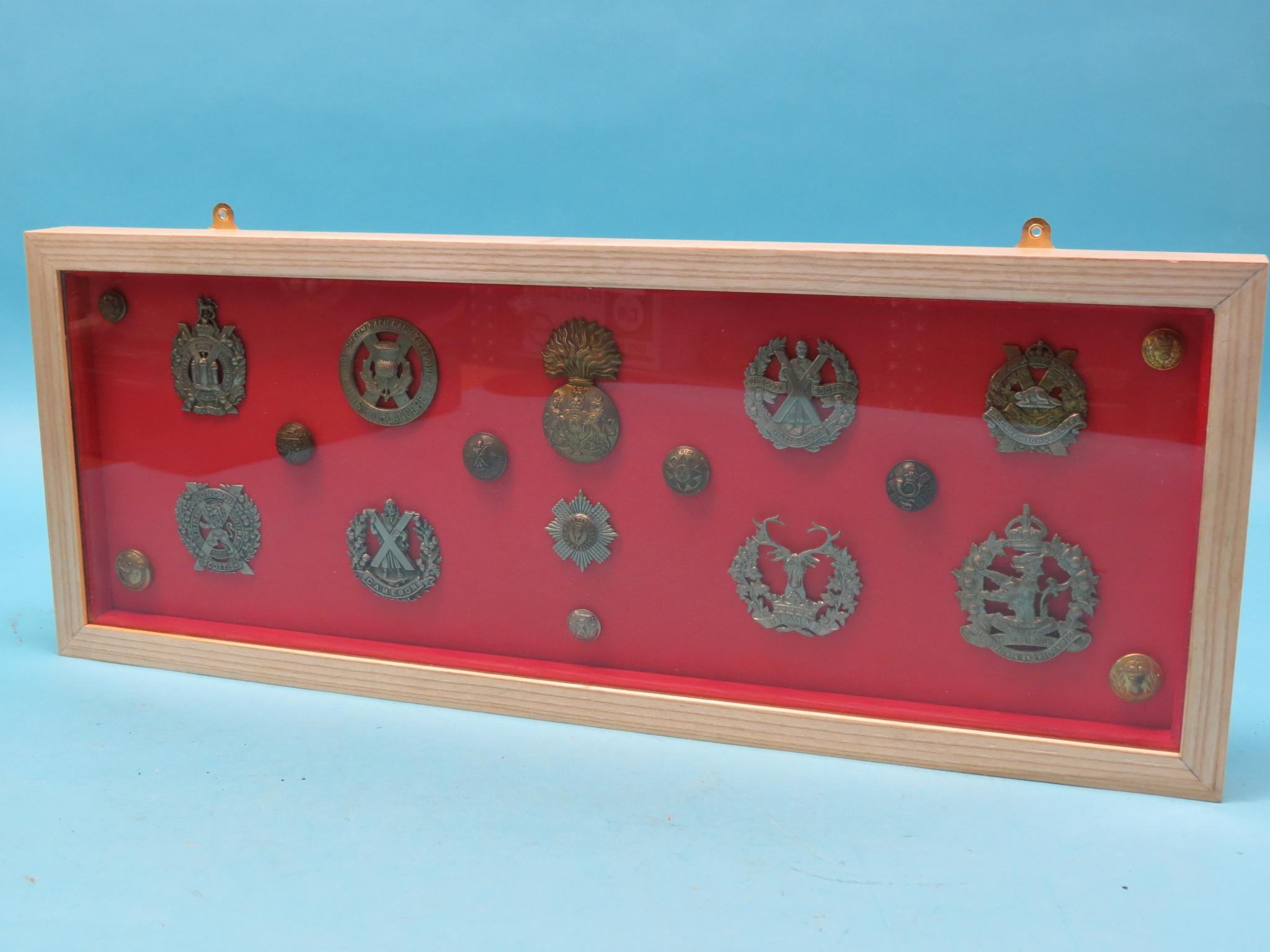 Appraisal: A framed collection of military badges and buttons total