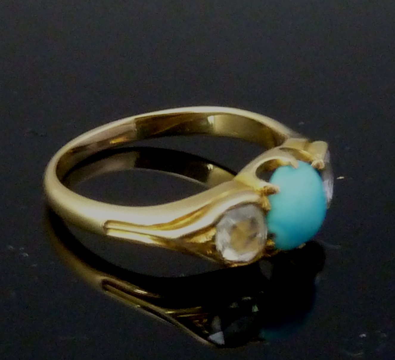 Appraisal: A turquoise and diamond three-stone ring the central turquoise bead